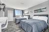 Two double beds in a modern, clean bedroom with minimalist styling.